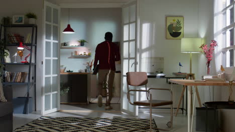 african american man finishing work on laptop at home