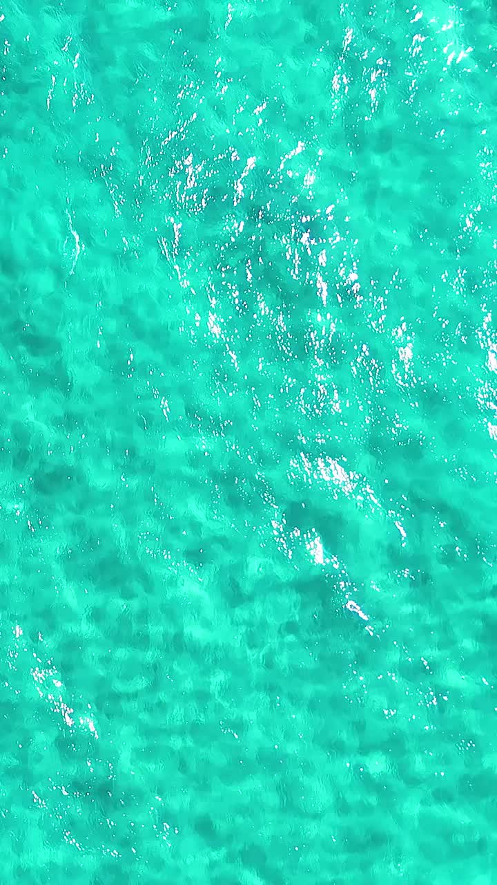 las olas turquesas del océano capturadas en la cabeza de los dedos