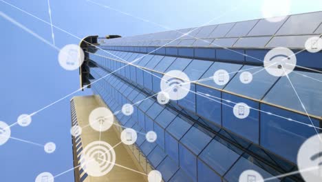 animación de iconos conectados con líneas sobre vista de ángulo bajo de un edificio de vidrio contra el cielo.