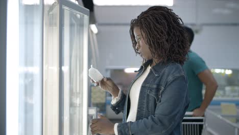 Customers-walking-in-aisle-and-taking-goods-from-fridge