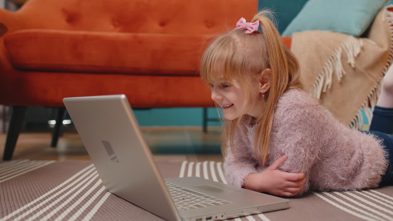 niña de escuela alegre usar computadora portátil aprender a leer lecciones de educación en línea sola en casa