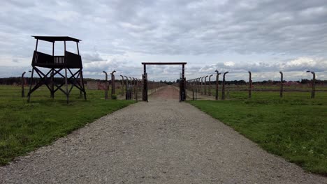 Dirt-Road-Between-Barbed-Wire-Fences-With-Watchtower