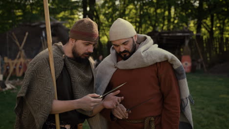 medieval men examining a knife