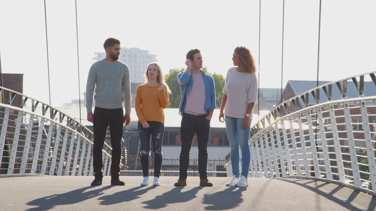Gruppo di giovani amici in piedi insieme su un ponte cittadino