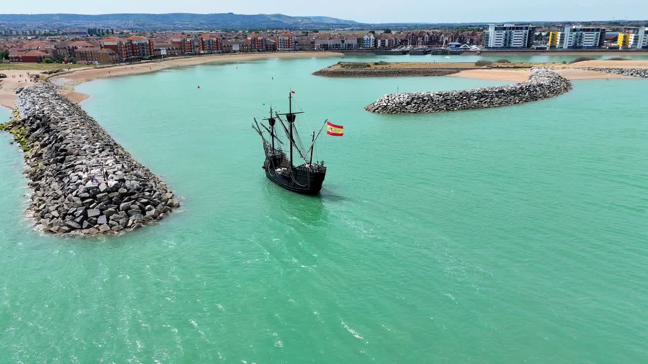Aerial view of the majestic Nao Victoria ship gliding into Sovereign Harbour, Eastbourne. Historic charm meets coastal beauty in this cinematic maritime moment.