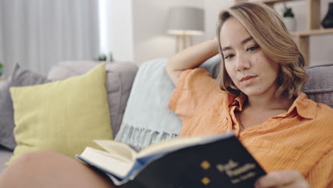 mujer, libro de religión y lectura en la sala de estar