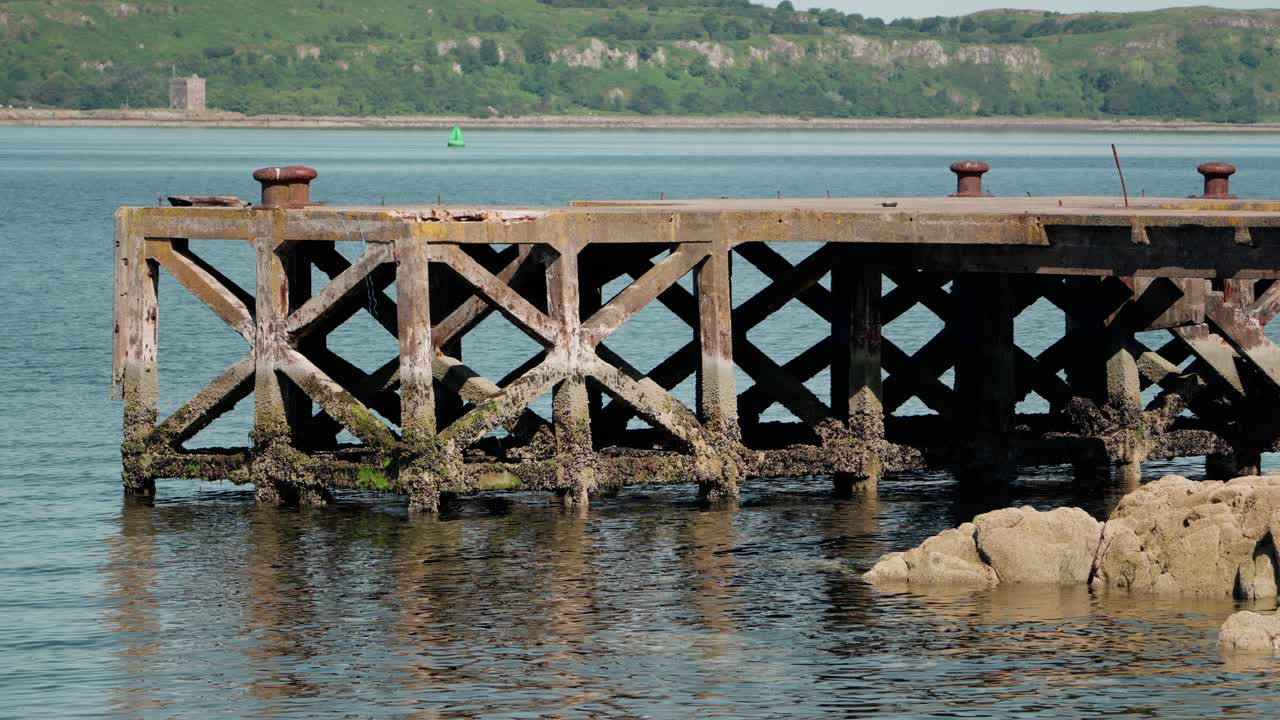 Rustic wooden pier at Portencross, Scotland, surrounded by calm coastal waters and scenic shoreline, highlighting historic charm and maritime heritage