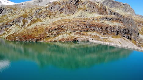 tranquilas aguas azules del lago weisssee y embalse junto a la montaña rocosa en salzburgo, austria