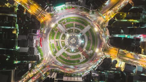 time-lapse or hyper-lapse aerial view 4 way road roundabout circle or intersection traffic at night for transportation concept.