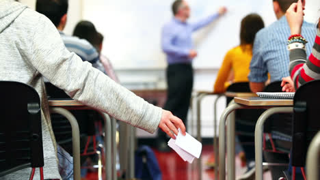 estudiantes pasando notas en la clase