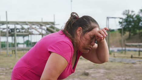 mujer caucásica cansada después de hacer ejercicio en el campamento de entrenamiento