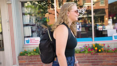 girl walks down sidewalk while wearing sunglasses