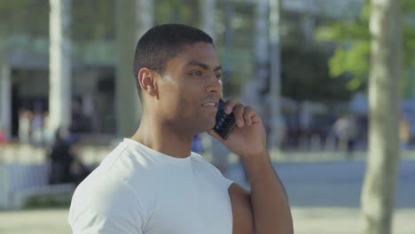 smiling african american sportsman talking on smartphone.