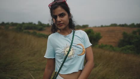 A-shot-of-a-beautiful-Indian-woman-in-a-light-blue-t-shirt-with-her-belly-button-showing