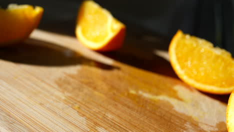 Grabbing-an-orange-fruit-slice-on-a-cutting-board-and-eating-it-to-the-peel-in-the-sunlight-for-a-healthy-snack