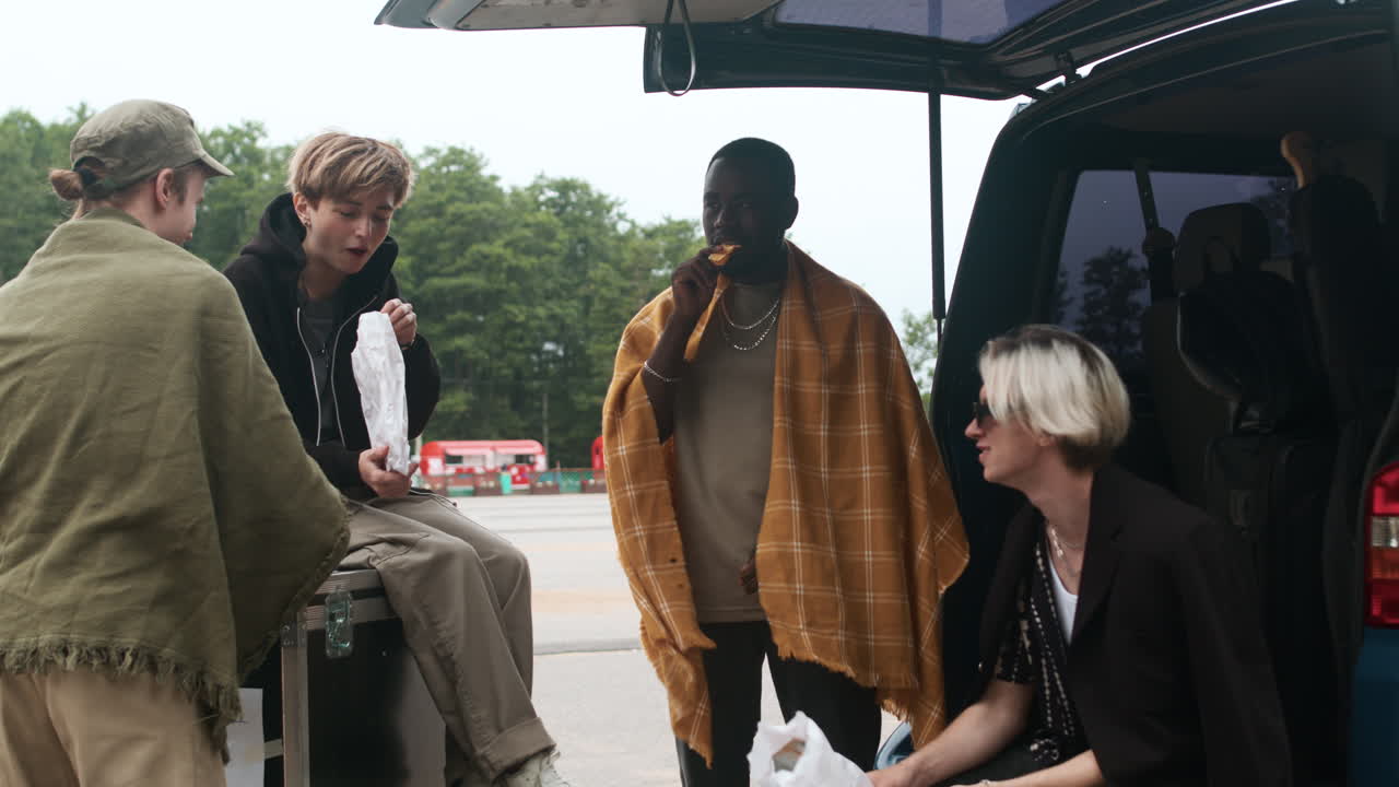 록 밴드 멤버들이 야외에서 이야기하고 있습니다.