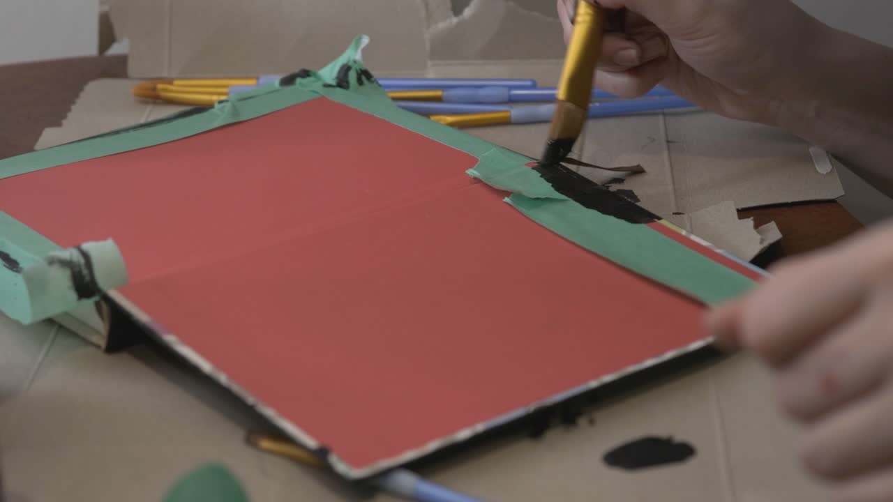 Man Applying Black Paint On The Red Border - Close Up Shot