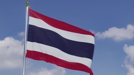 Bandera-De-Tailandia-Moviéndose-En-El-Viento-Con-Un-Cielo-Azul-Claro-En-El-Fondo,-Nubes-Moviéndose-Lentamente,-Asta-De-Bandera,-Cámara-Lenta