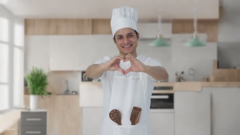 cocinero profesional indio feliz mostrando el signo del corazón