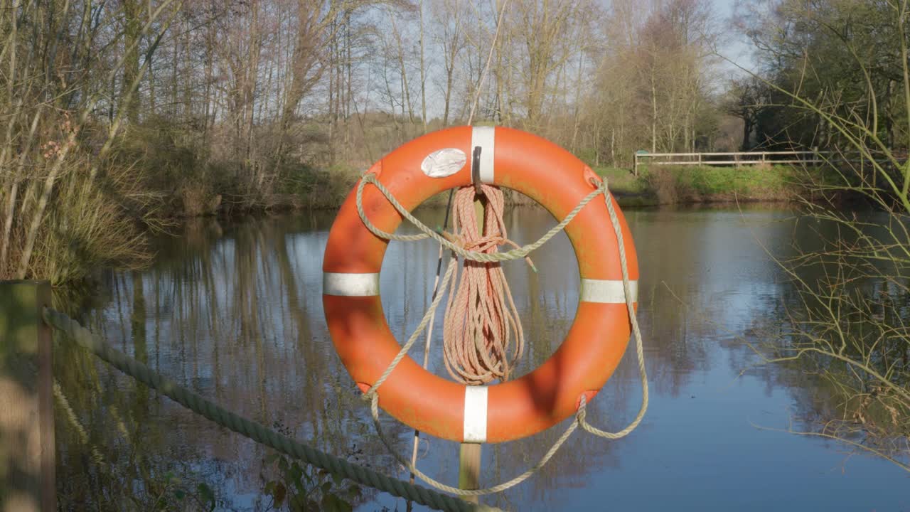 Calm lakeside with lifebuoy on a sunny day at Bilingford Lake