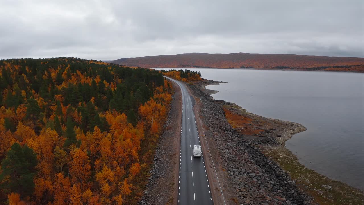 Winding road along a lake, autumn colors and forest landscapes in Vestarelen, Norway