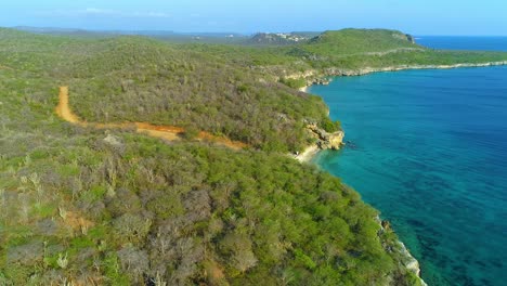 La-Plataforma-Rodante-De-Drones-De-Lado-A-Lado-Se-Eleva-Sobre-La-Playa-De-San-Juan-De-Curacao,-Con-Vista-Al-Agua-Clara-Del-Océano.