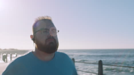 fitness, playa y hombre de tamaño grande corriendo en el camino