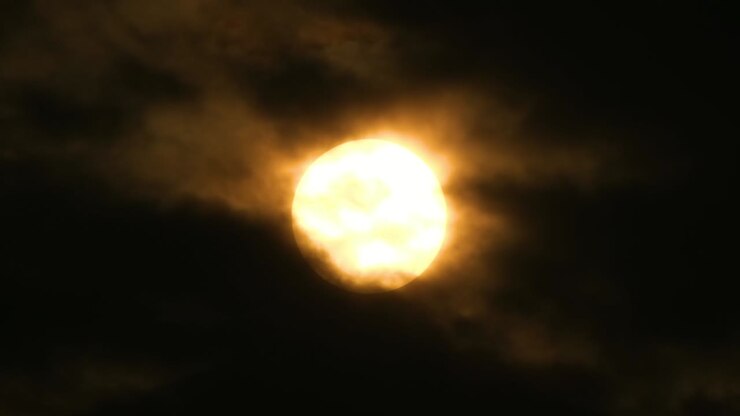 Big Full Moon with light rays getting covered by dark clouds