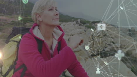 woman hiking rocky coastline, showing health technology through network connecting medical icons