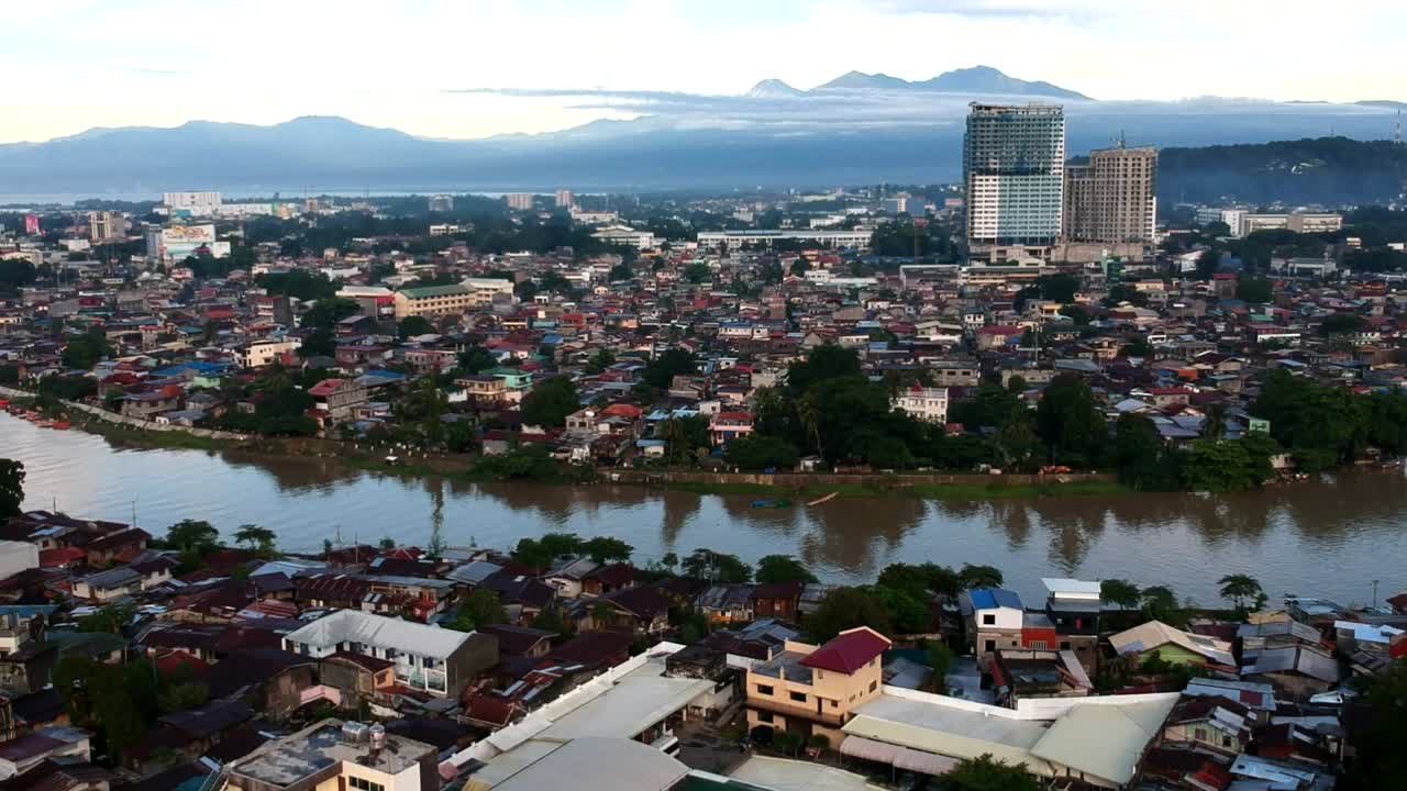 las tomas aéreas de drones del paisaje urbano de davao revelan una vegetación exuberante, la expansión urbana, el telón de fondo del monte apo y las serenas vistas costeras, mezclando naturaleza y modernidad.