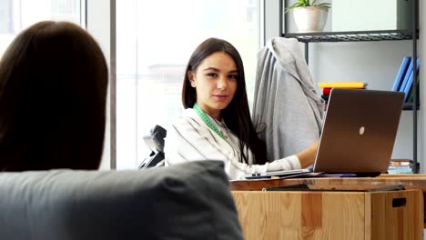 young attractive female designer discussing t-shirt with her colleague