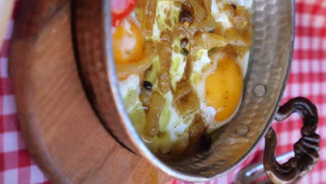 close-up of eggs with toppings in a metal pan