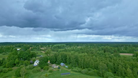 aerial drone tilt up shot over village houses surrounded by lush green vegetation on a cloudy day