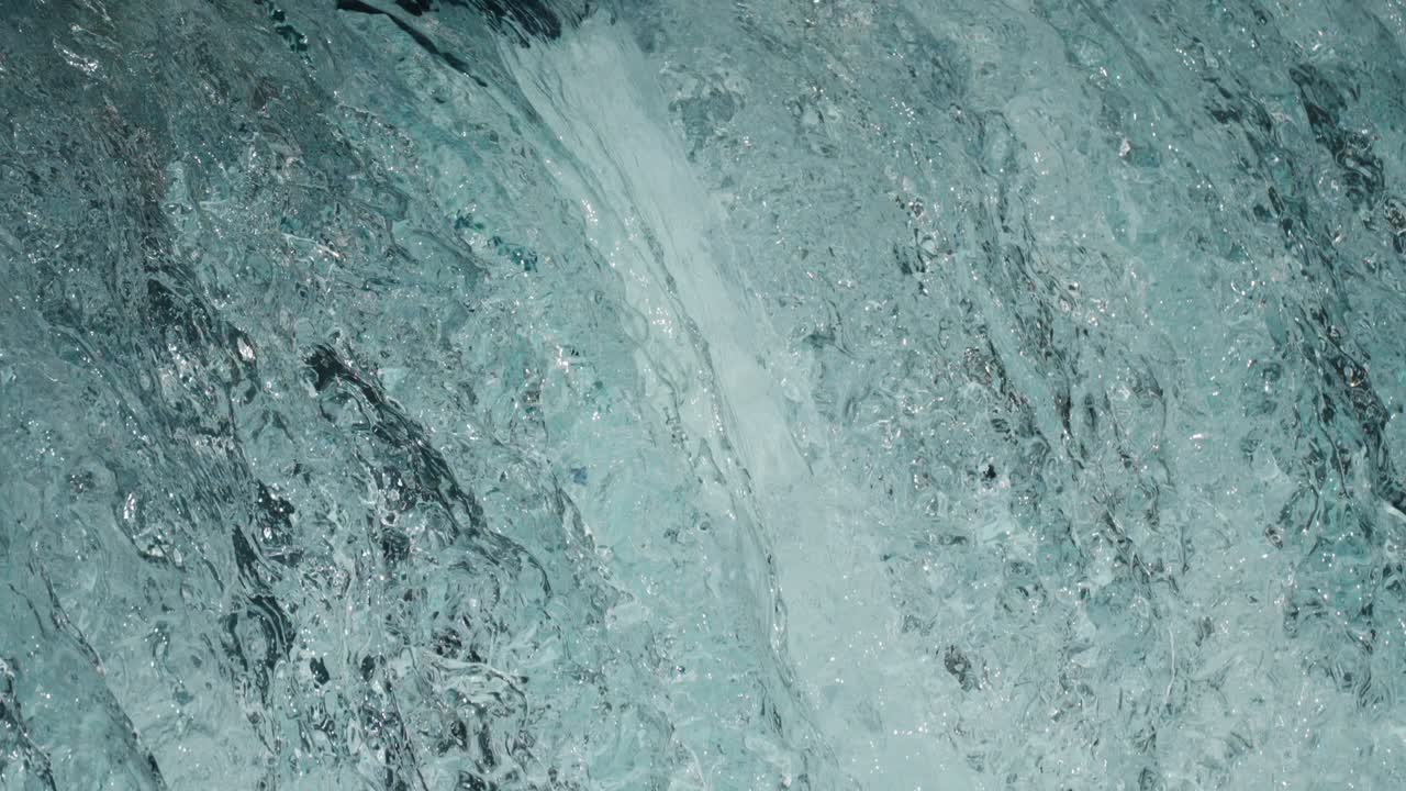 Ripresa ravvicinata al rallentatore dell'acqua cristallina che scende a cascata e si infrange dalle rocce
