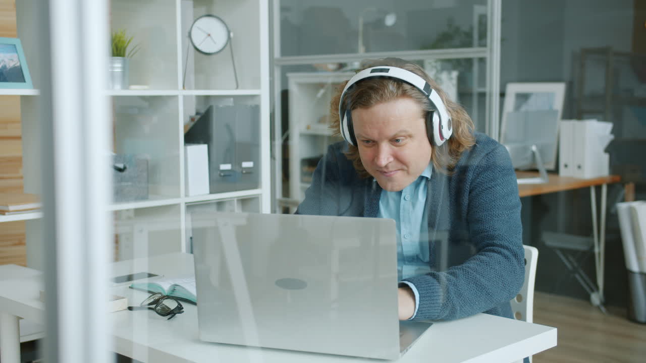 Man in Headphones Working on Laptop