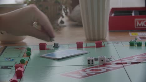 close up view of a person throwing the dices in a game of monopoly, filmed handheld in 4k