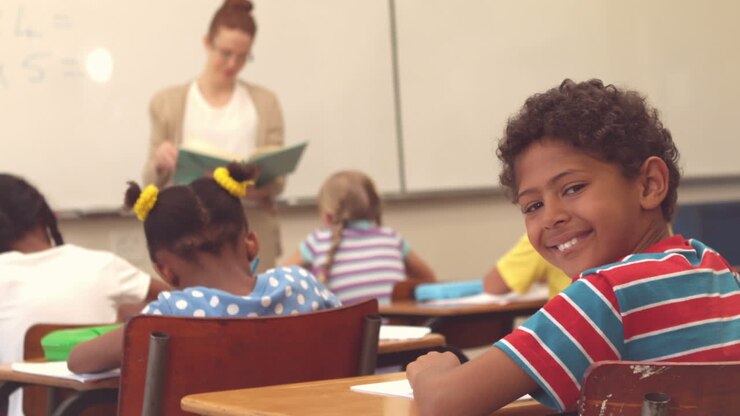 Aluno bonito sorrindo para a câmera na sala de aula