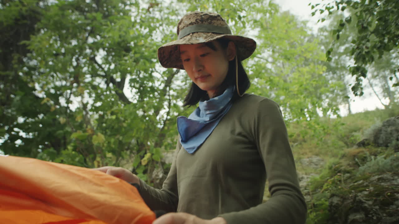 Asian Women Setting Up Tent at Campsite