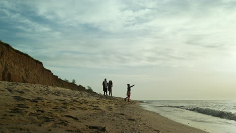 los padres y los hijos disfrutan de las olas de la playa de arena. las vacaciones en familia en la costa del océano.