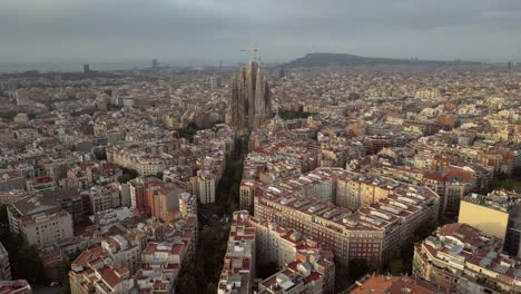 una vista aérea cinematográfica de las torres de la sagrada familia desde todos los ángulos, las calles de cataluña, así como el horizonte de los edificios altos y bajos 2
