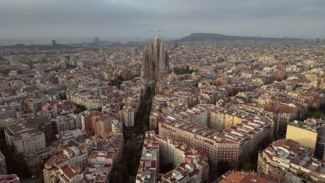 a cinematic aerial view of la sagrada familia towers from all angles, the streets of catalonia as well the skyline of high and low-rise buildings 2