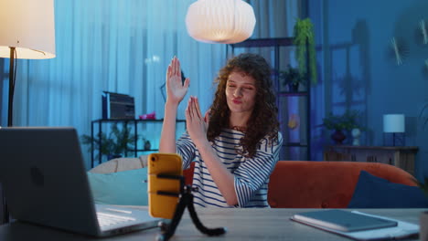 mujer joven tomando una selfie en un teléfono inteligente comunicándose grabando un retrato de video bailando en casa