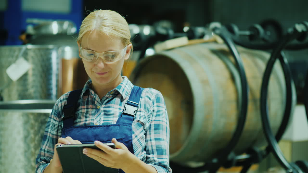 лаборант в защитных очках работает с планшетом в мастерской на фоне вина