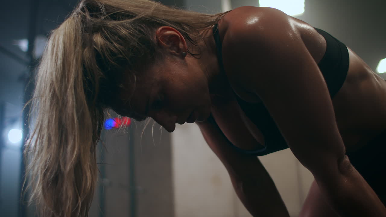 Tired woman breathing heavily after a workout sweat dripping demolition slow motion