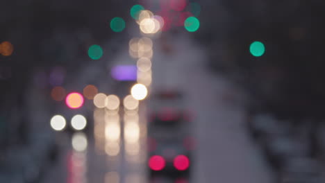 cámara lenta borrosa de una calle principal de manhattan de nueva york húmeda con tráfico, luces fuera de foco