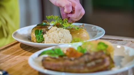 Close-up-shot-of-chef-hands-decorating-a-traditional-Slovenian-dish-with-edible-flowers