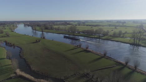 drone shot closing in on freighter boat going down the river