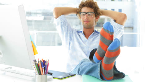 Relaxed-young-businessman-reclining-on-his-swivel-chair-