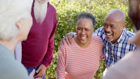 Happy-diverse-senior-female-and-male-friends-talking-and-laughing-in-sunny-garden,-slow-motion