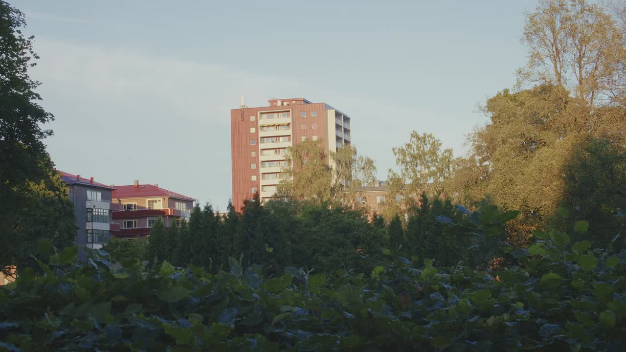 Apartment buildings behind lush green foliage in Oslo